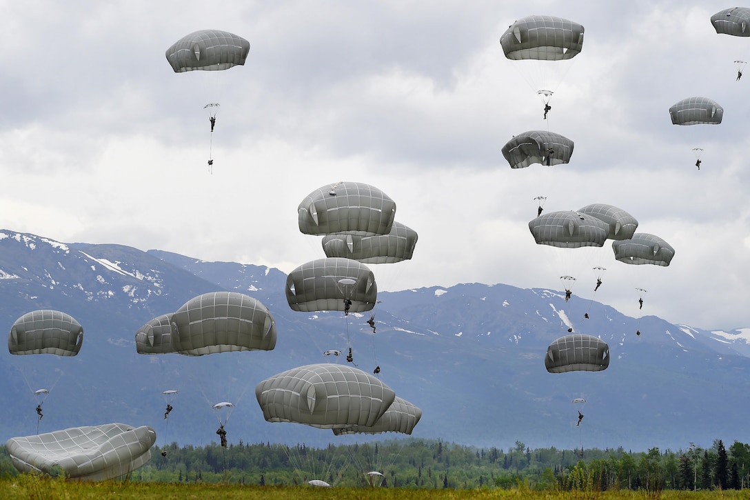 Paratroopers descend and land on Malemute drop zone during air transportability training at Joint Base Elmendorf-Richardson, Alaska, May 19, 2016. Air Force photo by Alejandro Pena