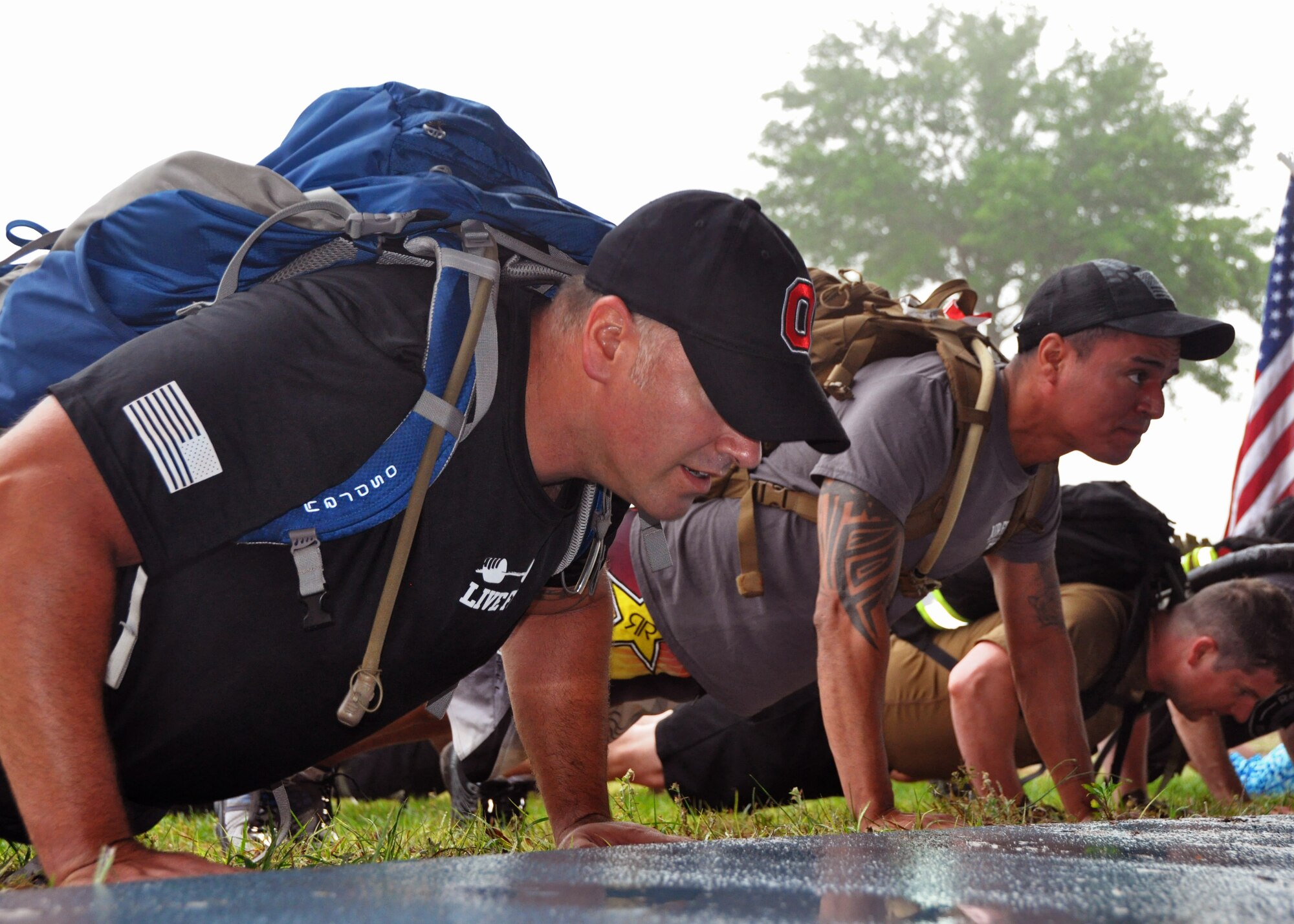 Airmen from across the 919th Special Operations Wing warm up with pushups during a GoRuck Challenge event May 12, 2016 at Duke Field, Fla.  The teambuilding exercise, based on special operations fitness training, put participants through a five-hour series of physically and mentally exhausting scenarios along an eight-mile ruck march.  (U.S. Air Force photo/Dan Neely)