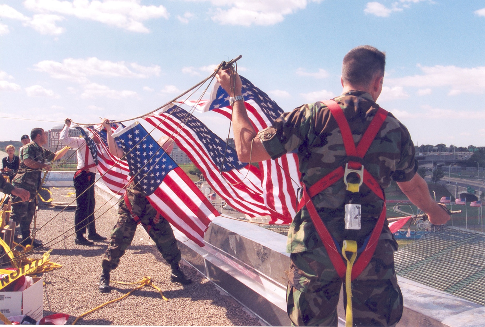 Service members display American flags at the Pentagon in Washington, D.C., for a 9/11 observance in 2002. (Courtesy photo)