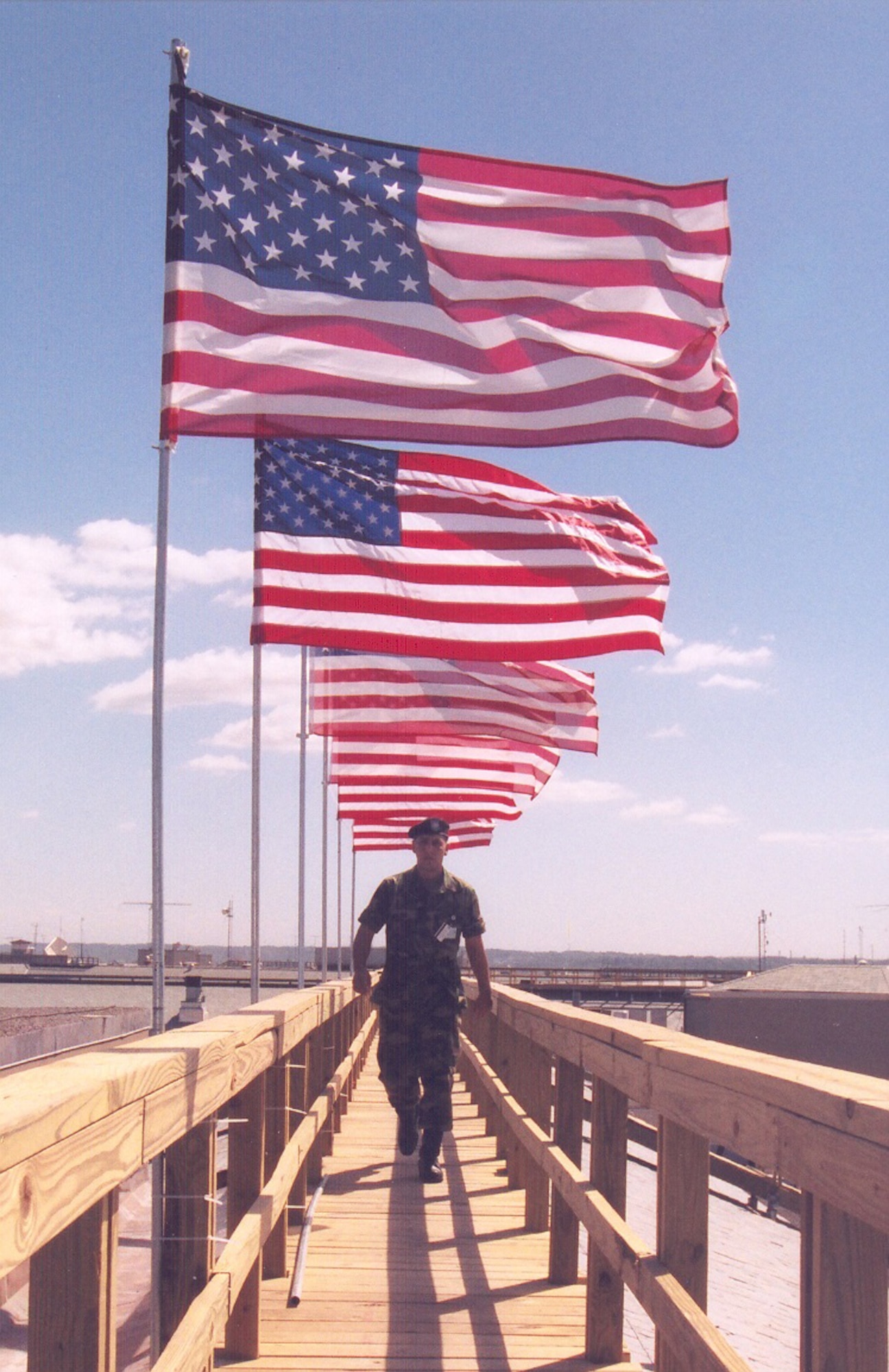 A service member walks under displayed American flags at the Pentagon in Washington, D.C., during a 9/11 observance in 2002. (Courtesy photo)