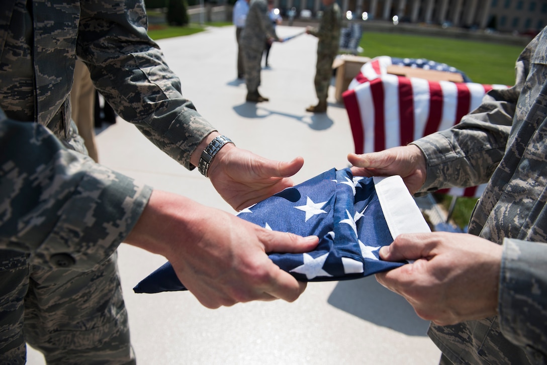Maj. Andrew Nye, left, and Maj. James Hogan fold an American flag in honor of Memorial Day outside of the Pentagon in Washington, D.C., May 25, 2016. (U.S. Air Force photo/Staff Sgt. Alyssa Gibson)