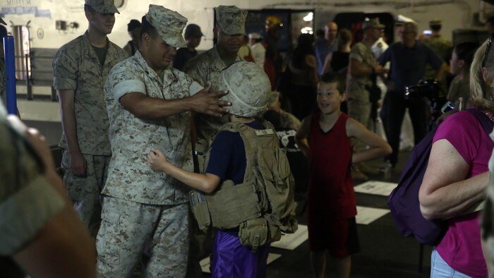 A Marine with Battalion Landing Team 3rd Battalion, 6th Marine Regiment, 24th Marine Expeditionary Unit, helps a resident of New York adjust his gear during Fleet Week New York, aboard the USS Bataan (LHD 5), May 27, 2016. This year is the 28th year New York has hosted Fleet Week.