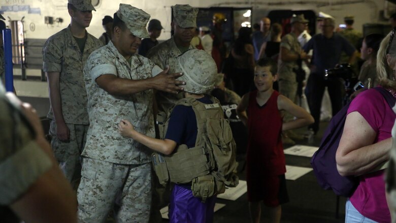 A Marine with Battalion Landing Team 3rd Battalion, 6th Marine Regiment, 24th Marine Expeditionary Unit, helps a resident of New York adjust his gear during Fleet Week New York, aboard the USS Bataan (LHD 5), May 27, 2016. This year is the 28th year New York has hosted Fleet Week.