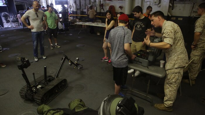 A Marine with the 24th Marine Expeditionary Unit teaches a resident of New York how to operate a robot designed for disposing bombs during Fleet Week New York, aboard the USS Bataan (LHD 5), May 27, 2016. This year is the 28th year New York has hosted Fleet Week.