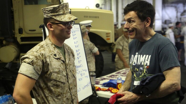 Cpl. Marcel Gaud, an administration specialist with the 24th Marine Expeditionary Unit, speaks about the Marine Corps with Adam Greisson, a resident of New York, during Fleet Week New York, aboard the USS Bataan (LHD 5), May 27, 2016. This year is the 28th year New York has hosted Fleet Week.