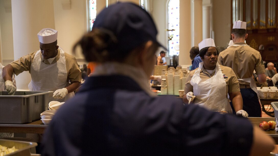 U.S. service members serve food at the Holy Apostles Soup Kitchen in New York, May 27, 2016 during Fleet Week. U.S. Marines, sailors and coast guardsmen visited the city to interact with the public, demonstrate capabilities and teach the people of New York about America's sea services.