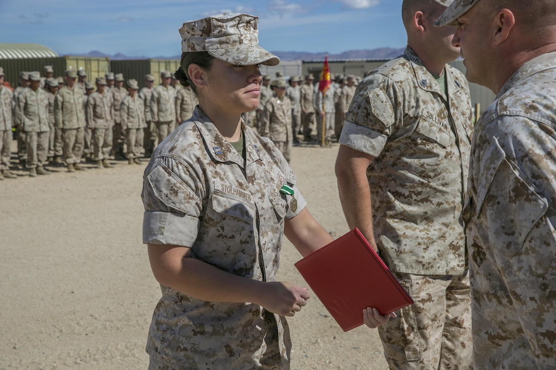 Lt. Col. Steven Murphy, commanding officer, Marine Wing Support Squadron 374, awards Capt. Elaine M. Stolhammer, logistics officer, MWSS-374, the Navy and Marine Corps Commendation medal following a 15 kilometer hike from the squadron’s headquarters building to Camp Wilson May 6, 2016. Stolhammer was awarded for her superior performance and dedication to her duty. (Official Marine Corps photo by Lance Cpl. Dave Flores/Released)