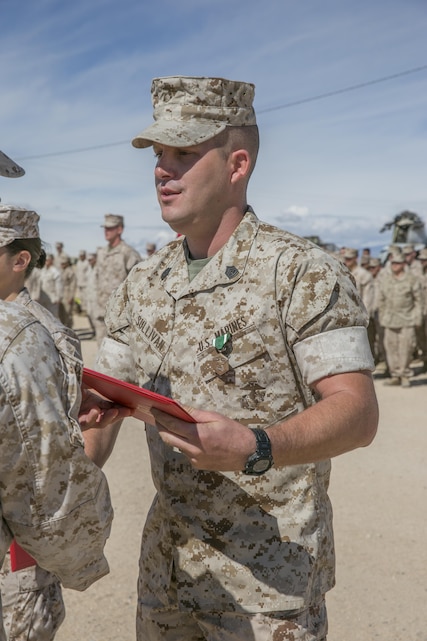 Lt. Col. Steven Murphy, commanding officer, Marine Wing Support Squadron 374, awards Gunnery Sgt. Steven J. Sullivan, logistics chief, MWSS-374, the Navy and Marine Corps Commendation medal after a 15 km hike from the squadron’s headquarters building to Camp Wilson May 6, 2016. Sullivan was awarded for his superior performance and dedication to his duty. (Official Marine Corps photo by Lance Cpl. Dave Flores/Released)