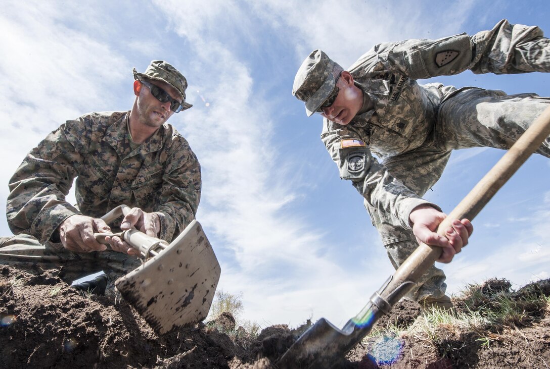 Marine Corps Sgt. Maj. Mike Grunst and Sgt. Robert Morrill dig a hole for a solar still during Khaan Quest 2016 in Ulaan Bataar, Mongolia, May 27, 2016. The exercise is a survival training course for U.S., Mongolian and Czech forces. Navy photo by Petty Officer 3rd Class Markus Castaneda