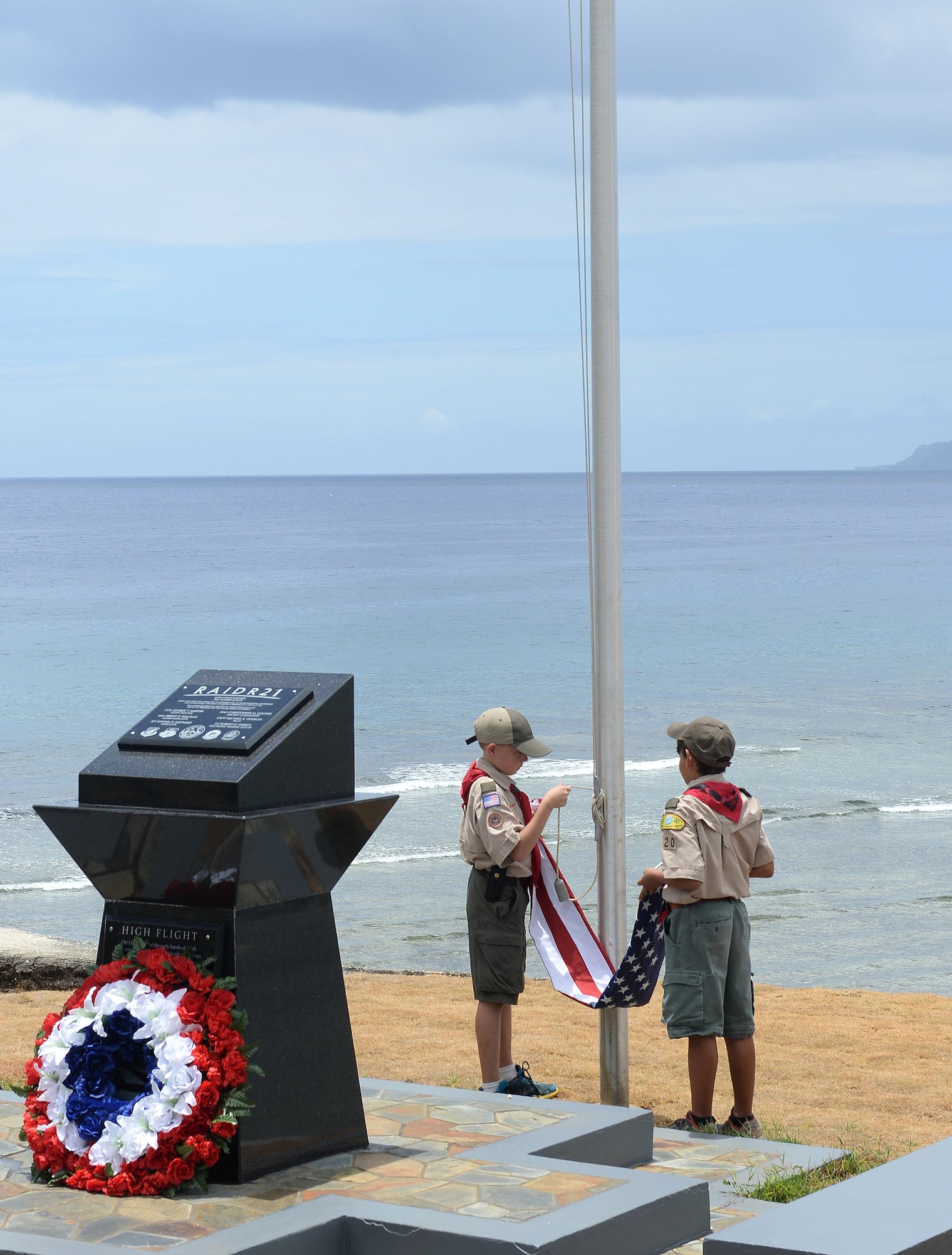 Two boy scouts prepare to hoist the American flag during the RAIDR 21 Re-dedication ceremony May 28, 2016, in Adelup, Guam. During the ceremony, attendees honored the six B-52 Stratofortress crew members who lost their lives July 21, 2008, during a training mission. (U.S. Air Force photo by Staff Sgt. Benjamin Gonsier)