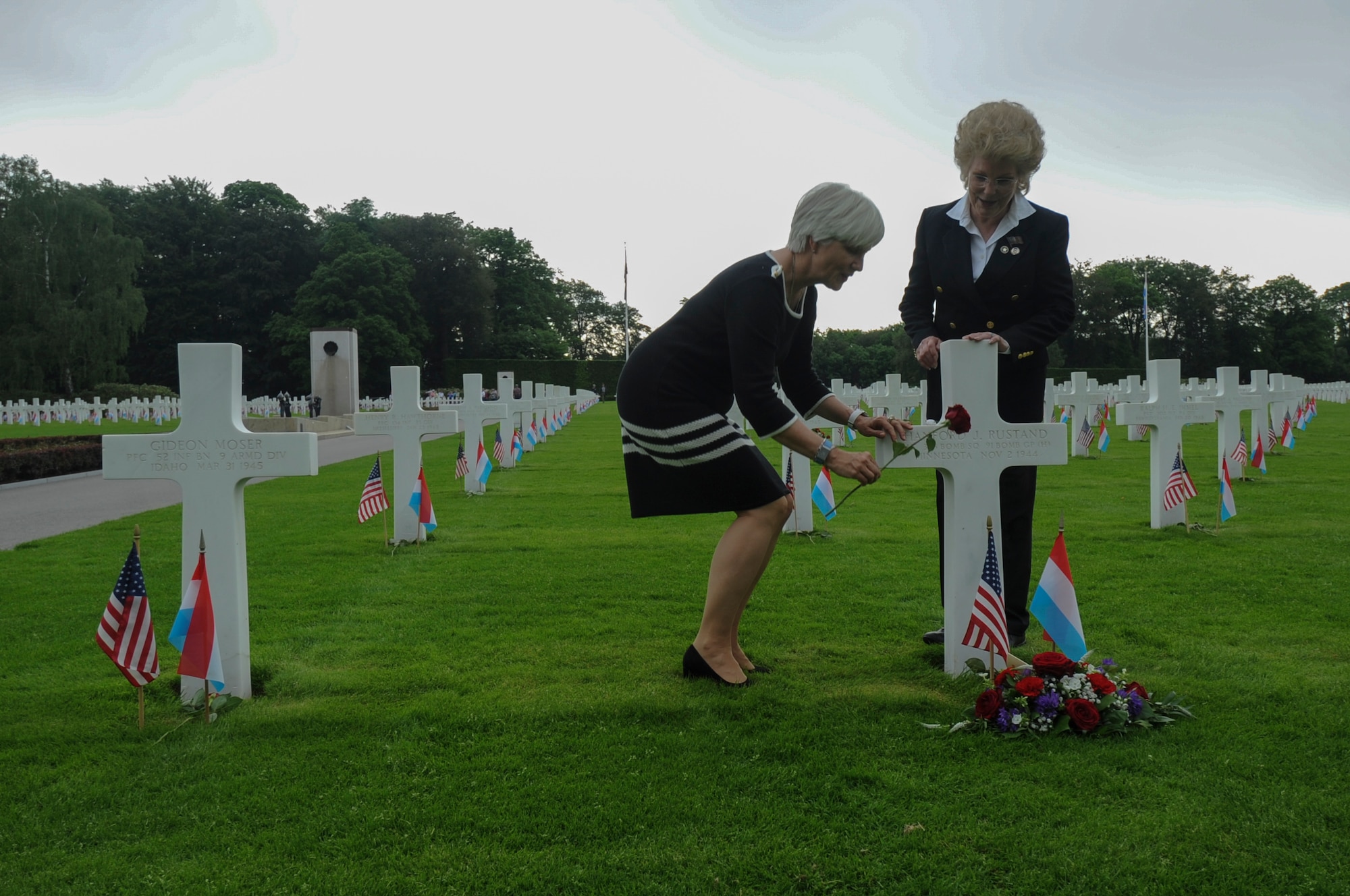 Helen Patton, granddaughter of U.S. Army Gen. George S. Patton, left, places a rose at the gravesite of U.S. Army Air Corps 1st Lt. Hanford "Rusty" J. Rustand, a B-17 bomber pilot killed in World War II, as Marilynn Rustand Lieurance, Rustand’s daughter, watches after a Memorial Day ceremony at the Luxembourg American Cemetery and Memorial in Luxembourg, May 28, 2016. Rustand died when his B-17 came under enemy fire during a mission near Merseburg, Germany, and crashed on Nov. 2, 1944, nearly half a year before Lieurance was born. Both Rustand and Patton’s grandfather are among the 5,076 American service members buried at the cemetery. (U.S. Air Force photo by Staff Sgt. Joe W. McFadden/Released)