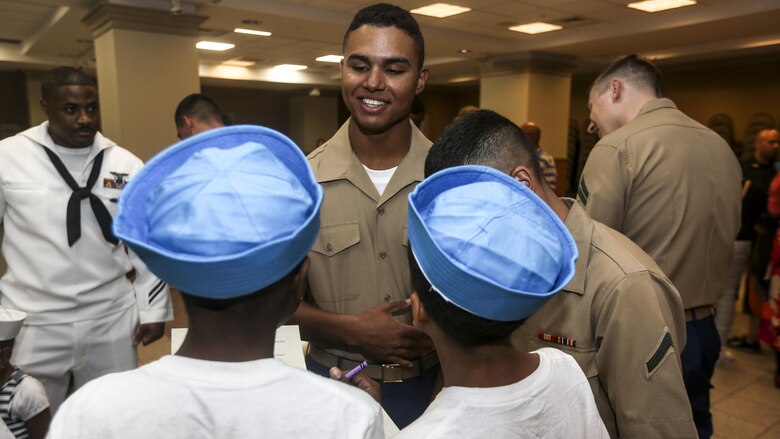 Pfc. Rafael Perguero, a rifleman with 3rd Battalion 6th Marine Regiment, speaks with two children in need during a Project HOPE event that brought aid to children and families in need at Times Square Church in New York, May 28, 2016. Fleet Week New York is an opportunity for the public to interact with service members from America’s sea services, spreading awareness of the Navy and Marine Corps’ missions at home and abroad.