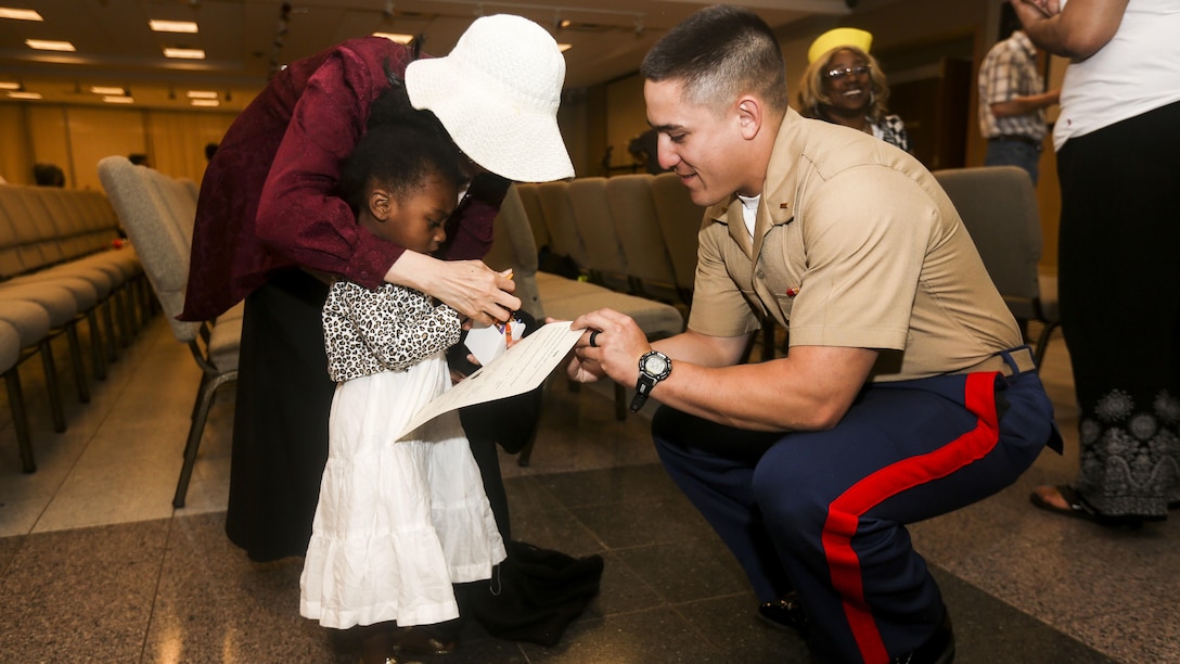 2nd Lt. Marc Martinez, a platoon commander with 3rd Battalion, 6th Marine Regiment, helps a girl complete an ice breaking exercise during an effort to bring aid and support to children in need at Times Square Church in New York, May 28, 2016. Fleet Week New York is an opportunity for the public to interact with service members from America’s sea services, spreading awareness of the Navy and Marine Corps’ missions at home and abroad.