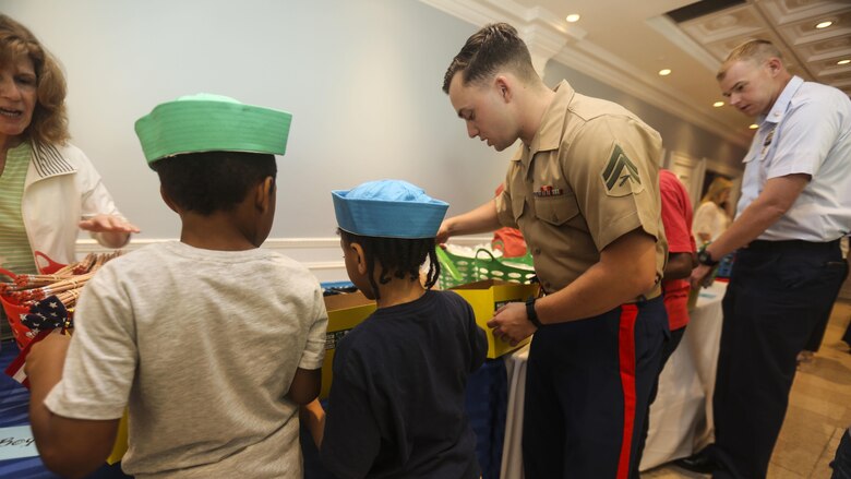 Cpl. William Linke, a rifleman with 3rd Battalion, 6th Marine Regiment, helps children build care packages during an effort to bring aid and support to children in need at Times Square Church in New York, May 28, 2016. Fleet Week New York is an opportunity for the public to interact with service members from America’s sea services, spreading awareness of the Navy and Marine Corps’ missions at home and abroad.