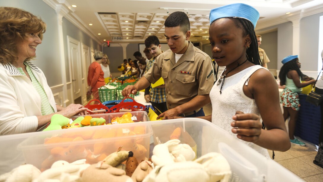Pfc. Miguel Ramirez Collon, a rifleman with 3rd Battalion, 6th Marine Regiment, selects gifts while building care packages with children during a Project HOPE event that brought aid to children and families in need during a Project HOPE event that brought aid to children and families in need at Times Square Church in New York, May 28, 2016. Fleet Week New York is an opportunity for the public to interact with service members from America’s sea services, spreading awareness of the Navy and Marine Corps’ missions at home and abroad.