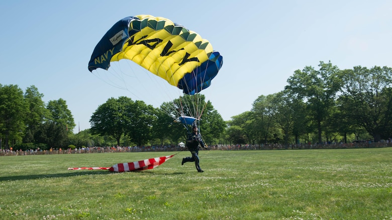 A member of the U.S. Navy Parachute Team, or the Leap Frogs, performs an aerial parachute demonstration during Military Day as part of Fleet Week at Eisenhower Park in East Meadow, New York, May 28, 2016. The Marines and sailors are visiting to interact with the public, demonstrate capabilities and teach the people of New York about America’s sea services.