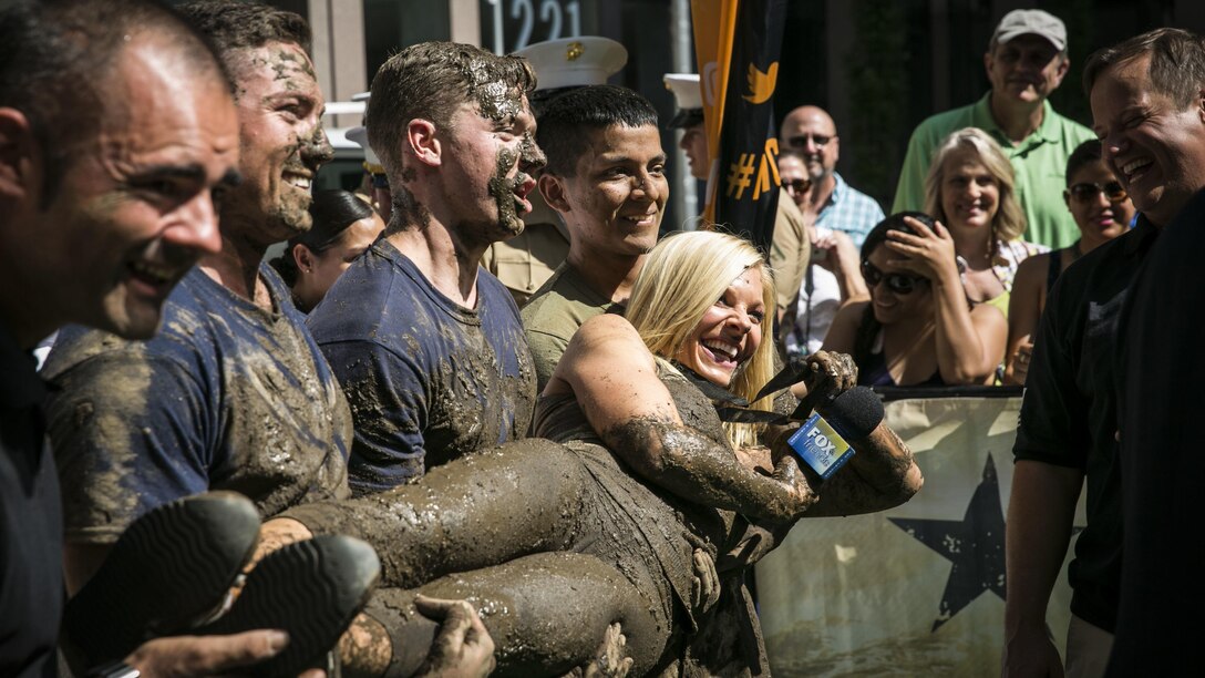 Marines with the 24th Marine Expeditionary Unit pose with Anna Kooiman, a Fox News anchor, during the Fox and Friends Weekend news program, May 28, 2016. U.S. Marines and sailors are in New York for Fleet Week to interact with the public, demonstrate capabilities and teach the people of New York about America's sea services.
