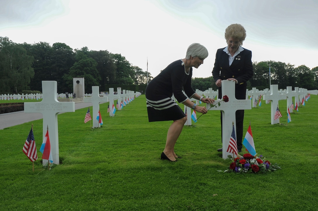 Helen Patton, granddaughter of Army Gen. George S. Patton, left, places a rose at the gravesite of Army Air Corps 1st Lt. Hanford "Rusty" J. Rustand, a B-17 bomber pilot killed in World War II, as Marilynn Rustand Lieurance, Rustand’s daughter, watches after a Memorial Day ceremony at the Luxembourg American Cemetery and Memorial in Luxembourg, May 28, 2016. Rustand died when his B-17 came under enemy fire during a mission near Merseburg, Germany, and crashed on Nov. 2, 1944. Rustand and Patton’s grandfather are among the 5,076 American service members buried at the cemetery. Air Force photo by Staff Sgt. Joe W. McFadden