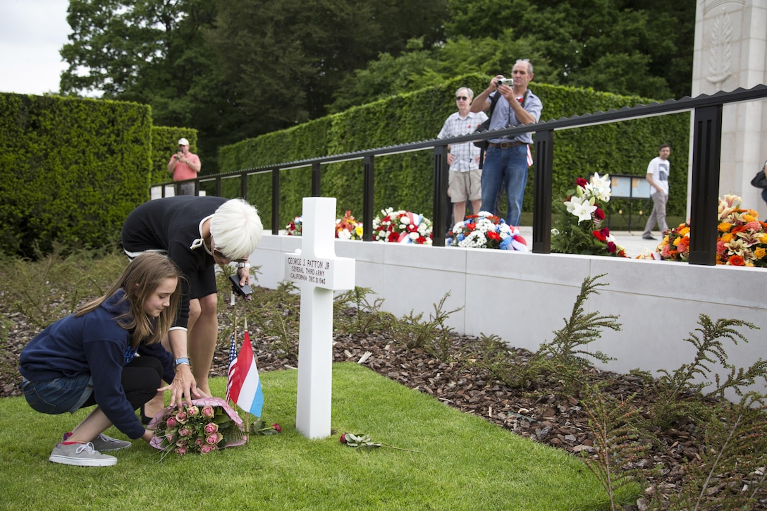 Helen Patton, second from left, the granddaughter of Army Gen. George S. Patton Jr., places roses on his grave after a Memorial Day ceremony in Luxembourg City, Luxembourg, May 28, 2016. Hundreds of soldiers, airmen, Marines, family members, local citizens and guests gathered at the Luxembourg American Cemetery and Memorial to honor fallen U.S. service members. Army photo by Spc. Tracy McKithern
