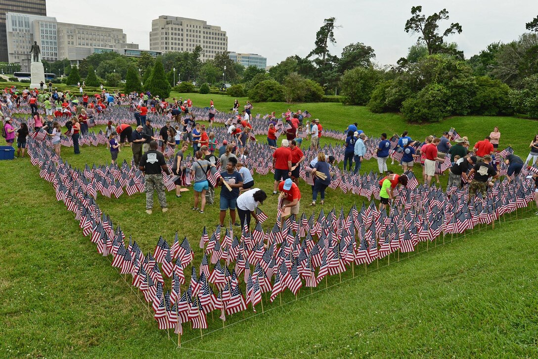 Members of the Louisiana National Guard and volunteers help place over 11,000 American flags on the lawn of the state Capitol in Baton Rouge, La., May 27, 2016, to honor Louisiana fallen service members. National Guard photo by Master Sgt. Toby Valadie