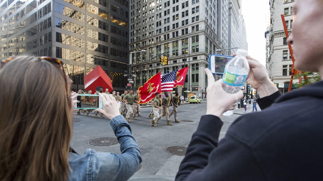 Observers take photos of Marines with the 24th Marine Expeditionary Unit as they run through the city streets during the Freedom Run as part of Fleet Week in New York, May 29, 2016. Service members from U.S. Marine Corps, U.S. Navy and Candadian Navy ran from the North Cove Marina to the 9/11 Memorial to honor the fallen.