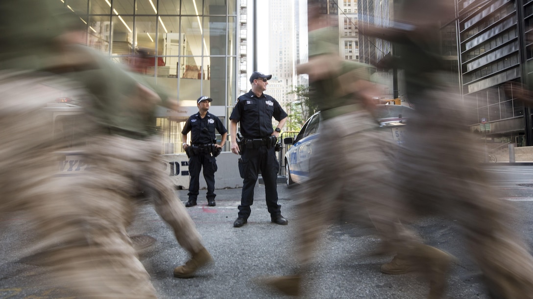 Policemen with the New York City Police Department watch as Marines with the 24th Marine Expeditionary Unit run through the city streets during the Freedom Run as part of Fleet Week in New York, May 29, 2016. Service members from U.S. Marine Corps, U.S. Navy and Candadian Navy ran from the North Cove Marina to the 9/11 Memorial to honor the fallen.