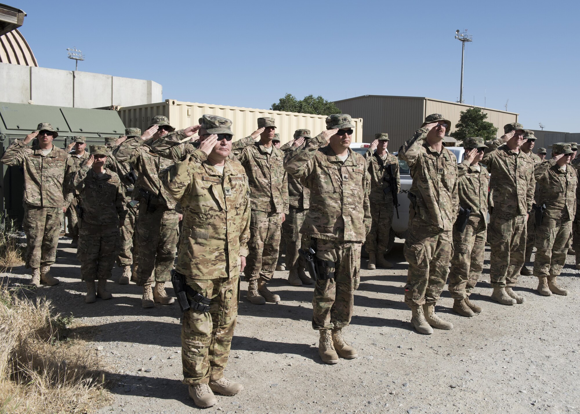 Col. Patrick Schlichenmeyer, 455th Air Expeditionary Wing vice commander and Airmen from across the 455th AEW, render a salute during the Memorial Day remembrance ceremony at Bagram Airfield, Afghanistan, May 30, 2016. The ceremony was held in honor of those who paid the ultimate price in service to the United States. (U.S. Air Force photo by Tech. Sgt. Tyrona Lawson)
