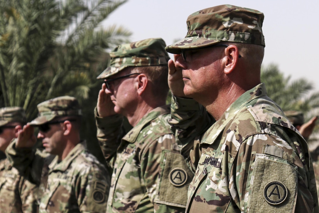 Soldiers salute the flag during the Memorial Day service the U.S. Army Central and Area Support Group-Kuwait hosted at Camp Arifian, Kuwait, May 30, 2016. The ceremony brings the Camp Arifian community together to honor fallen service members.