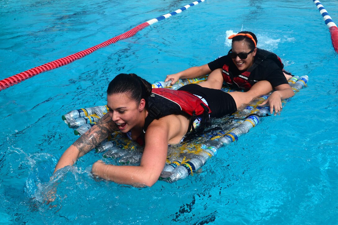 Staff Sgt. Vanessa Gann and Airman 1st Class Meagan French, 36th Comptroller Squadron, paddle a homemade boat during the Boat Blitz May 25, 2016, at Andersen Air Force Base, Guam. The Boat Blitz brought more than 40 people together to race boats made entirely of plastic bottles and duct tape against other Airmen and children. (U.S. Air Force photo by Airman 1st Class Alexa Ann Henderson)