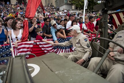 A veteran representing the 99th Infantry Division shakes hands with the crowd along Constitution Avenue in the 2016 National Memorial Day Parade in Washington, D.C., May 30. (U.S. Army photo by Master Sgt. Michel Sauret)