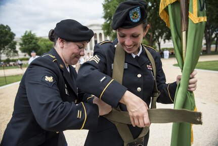 Spc. Amber Wardell, U.S. Army Reserve Soldier with the 400th Military Police Battalion, from Fort Meade, Maryland, helps Sgt. Brittany Albanese, with the 443rd MP Company, adjust her flag carrier harness prior to marching in the 2016 National Memorial Day Parade in Washington, D.C., May 30. The U.S. Army Reserve was represented by Soldiers from the 200th Military Police Command, from Fort Meade, Maryland; the 55th Sustainment Brigade, from Fort Belvoir, Virginia; and the Military Intelligence Readiness Command, from Fort Belvoir. (U.S. Army photo by Master Sgt. Michel Sauret)