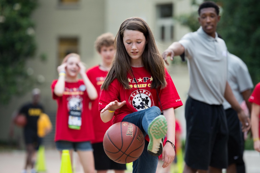 Kristin Drewry dribbles a basketball under the supervision of National Basketball Association players who volunteered to participate in an evening at the Pentagon for members of the Tragedy Assistance Program for Survivors in Arlington, Va. May 27, 2016. Defense Secretary Ash Carter hosted the event. DoD photo by EJ Hersom