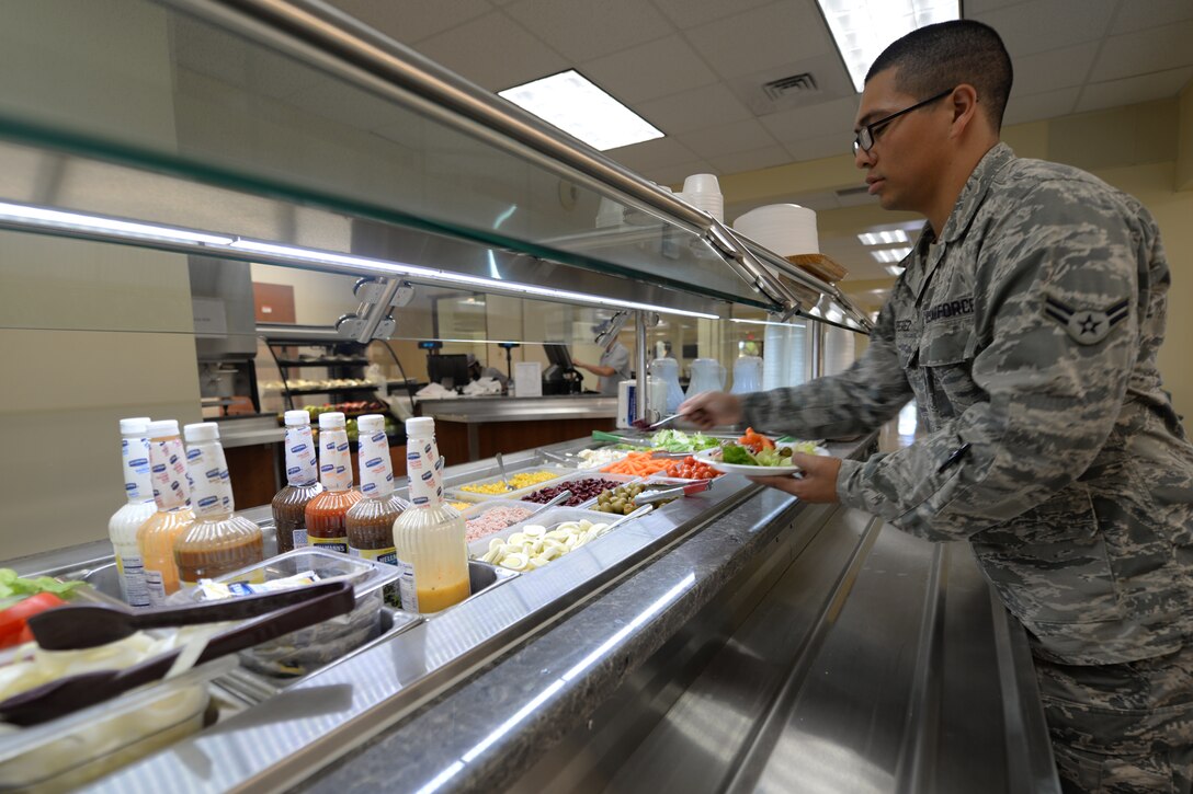 Airman 1st Class Mario Perez, 36th Force Support Squadron, makes a salad in the Magellan Inn Dining Facility May 31, 2016, at Andersen Air Force Base, Guam. The newly renovated dining facility offers improved serving lines, charging stations where customers can charge their electronic devices and more menu options for Airmen. (U.S. Air Force photo by Tech. Sgt. Richard Ebensberger)