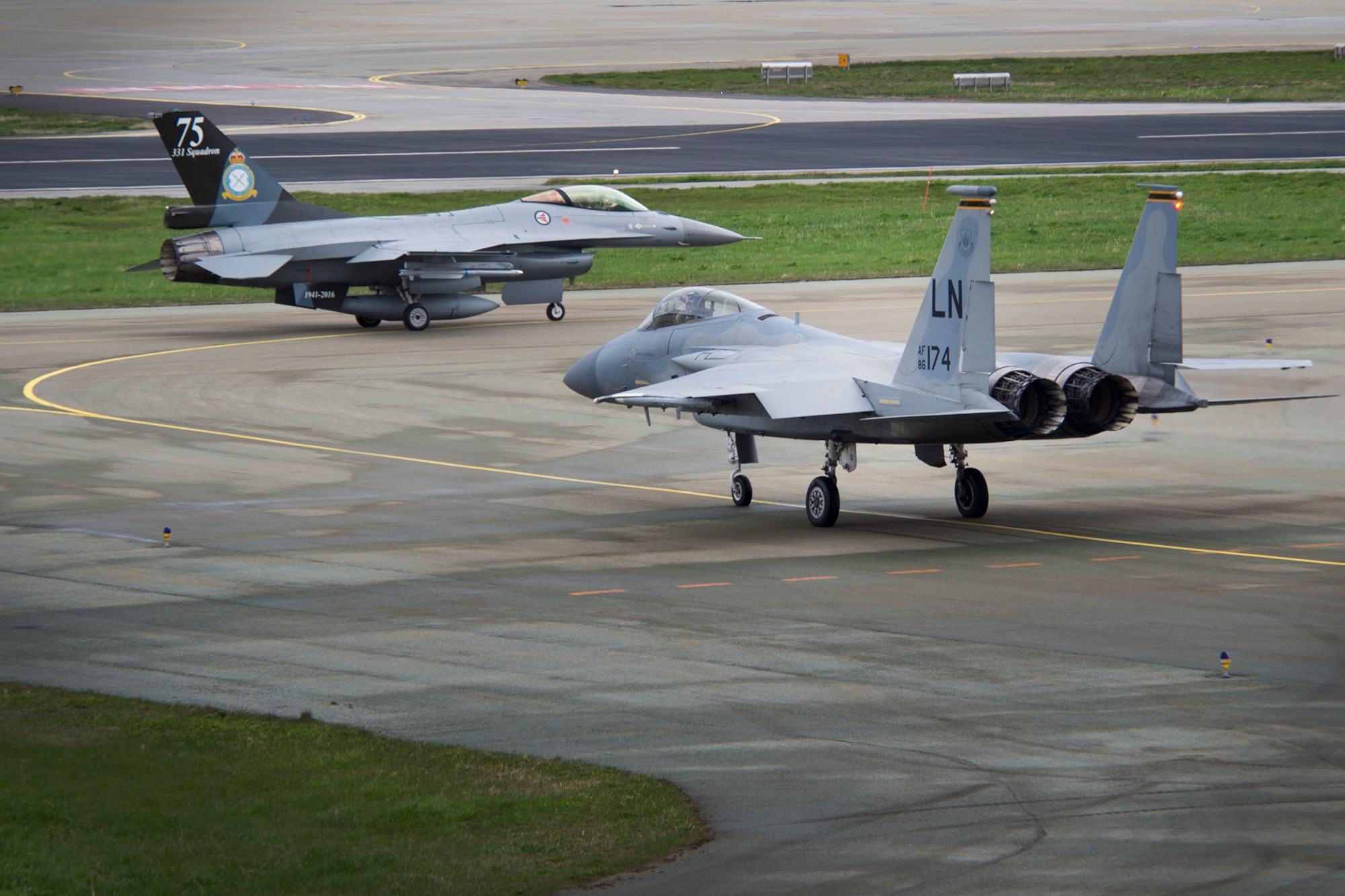 A 493rd Fighter Squadron F-15C Eagle and a Royal Norwegian Air Force F-16 Fighting Falcon taxi to the runway for training exercise Arctic Fighter Meet 2016, Bodø Main Air Station, Norway, May 25, 2016. This training exercise allowed forward-based U.S. Airmen and aircraft from RAF Lakenheath to train with NATO Allies and European partners, building on skill sets and improving every nation's ability to seamlessly work together. (U.S. Air Force photo/Senior Airman Erin Babis/Released)