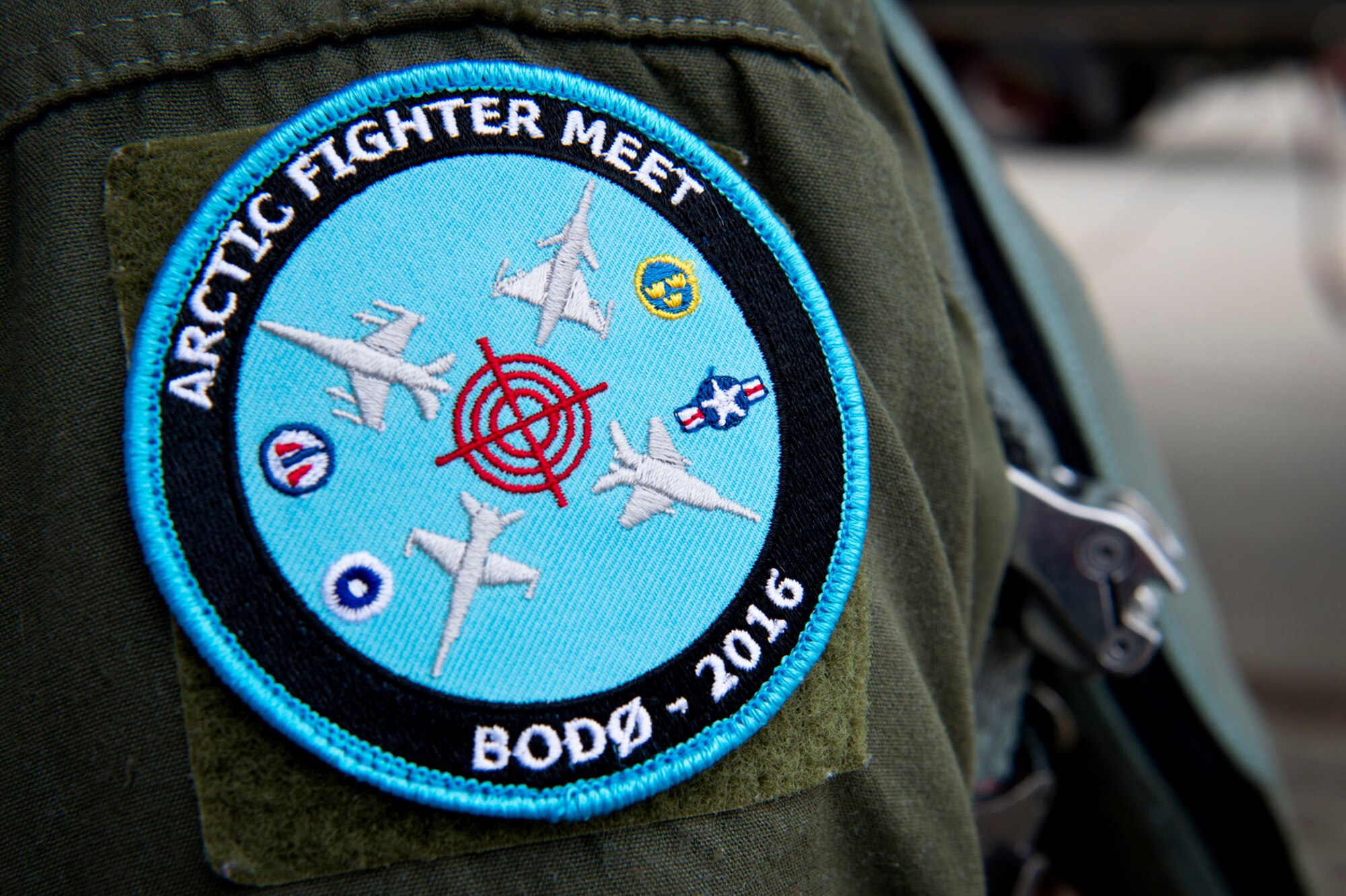 The Arctic Fighter Meet 2016 patch representing the countries and aircraft participating in the training exercise at Bodø Main Air Station, Norway, May 25, 2016. F-15s from Royal Air Force Lakenheath trained with Norwegian F-16s, Swedish Gripens and Finnish F-18s. (U.S. Air Force photo/Senior Airman Erin Babis/Released) 