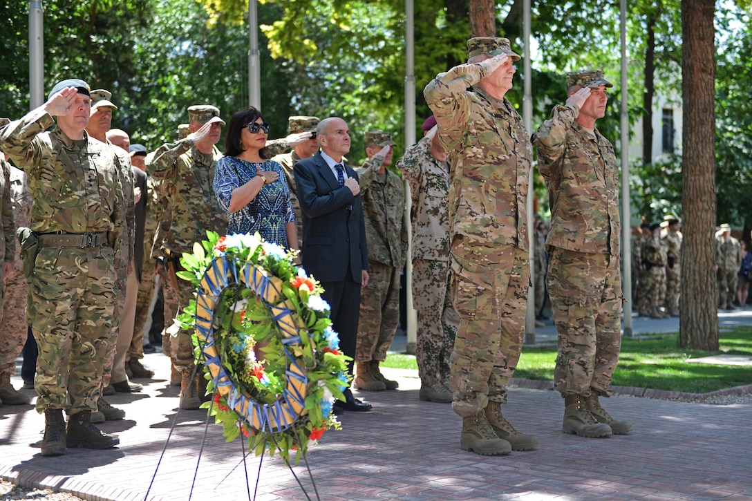 Army Gen. John W. Nicholson, Jr., center left, commander of U.S. and NATO forces in Afghanistan, and Army Command Sergeant Major Byers, lead coalition service members and civilians in saluting the flag during the Memorial Day remembrance ceremony in Kabul, Afghanistan, May 28, 2016. Army photo