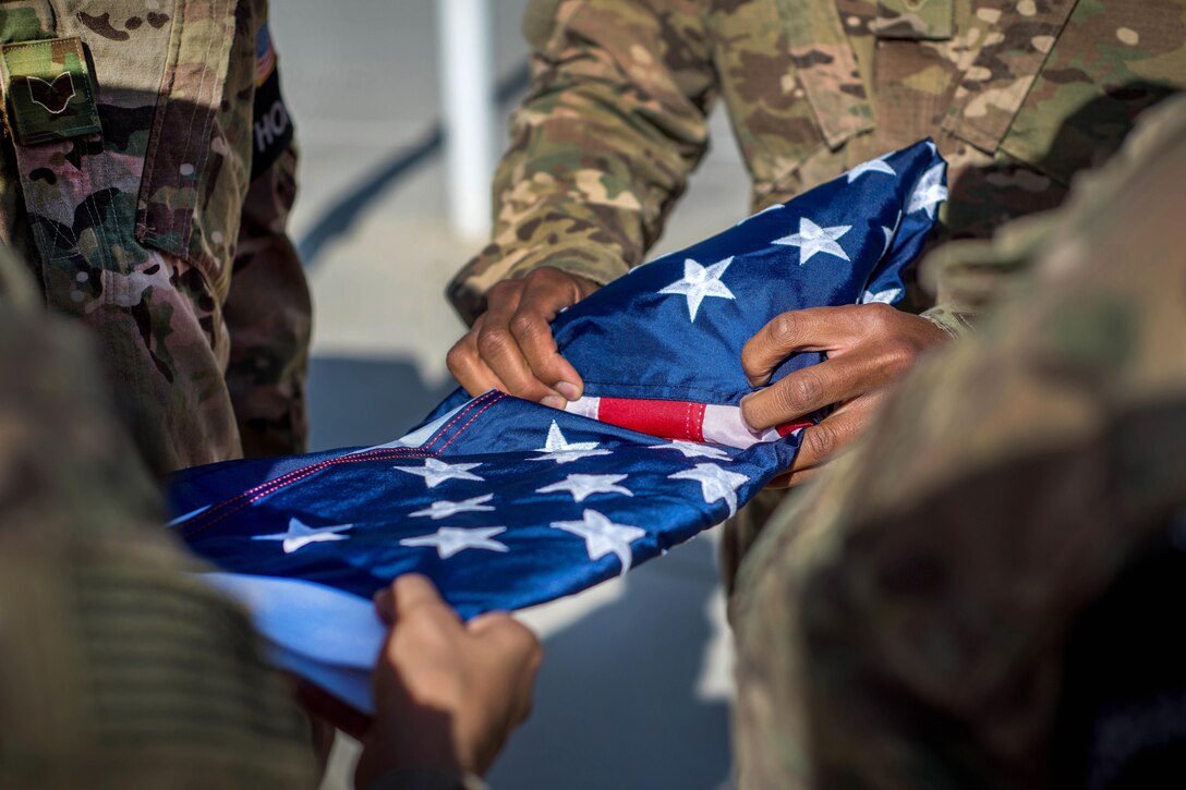 Members of the honor guard fold the flag during the Memorial Day remembrance ceremony at Bagram Airfield, Afghanistan, May 30, 2016. Air Force photo by Senior Airman Robert Dantzler