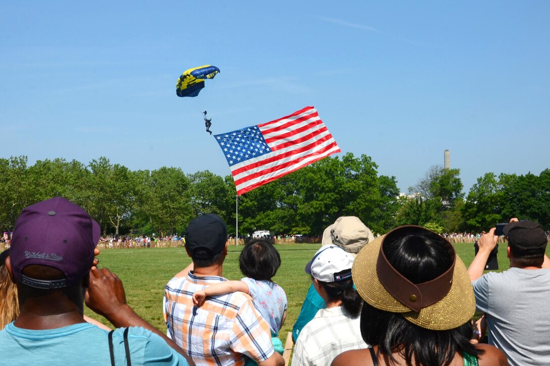 A sailor assigned to the Leap Frogs, the Navy's parachute team, pulls the American flag while preparing to land at Eisenhower Park during Fleet Week New York in East Meadow, N.Y., May 28, 2016. Navy photo by Chief Petty Officer Travis Simmons