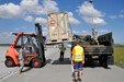 Polish Airport personnel at Gdańsk Lech Wałęsa Airport help the Oklahoma National guard with loading a pallet onto a Light Medium Tactical Vehicle, May 25.