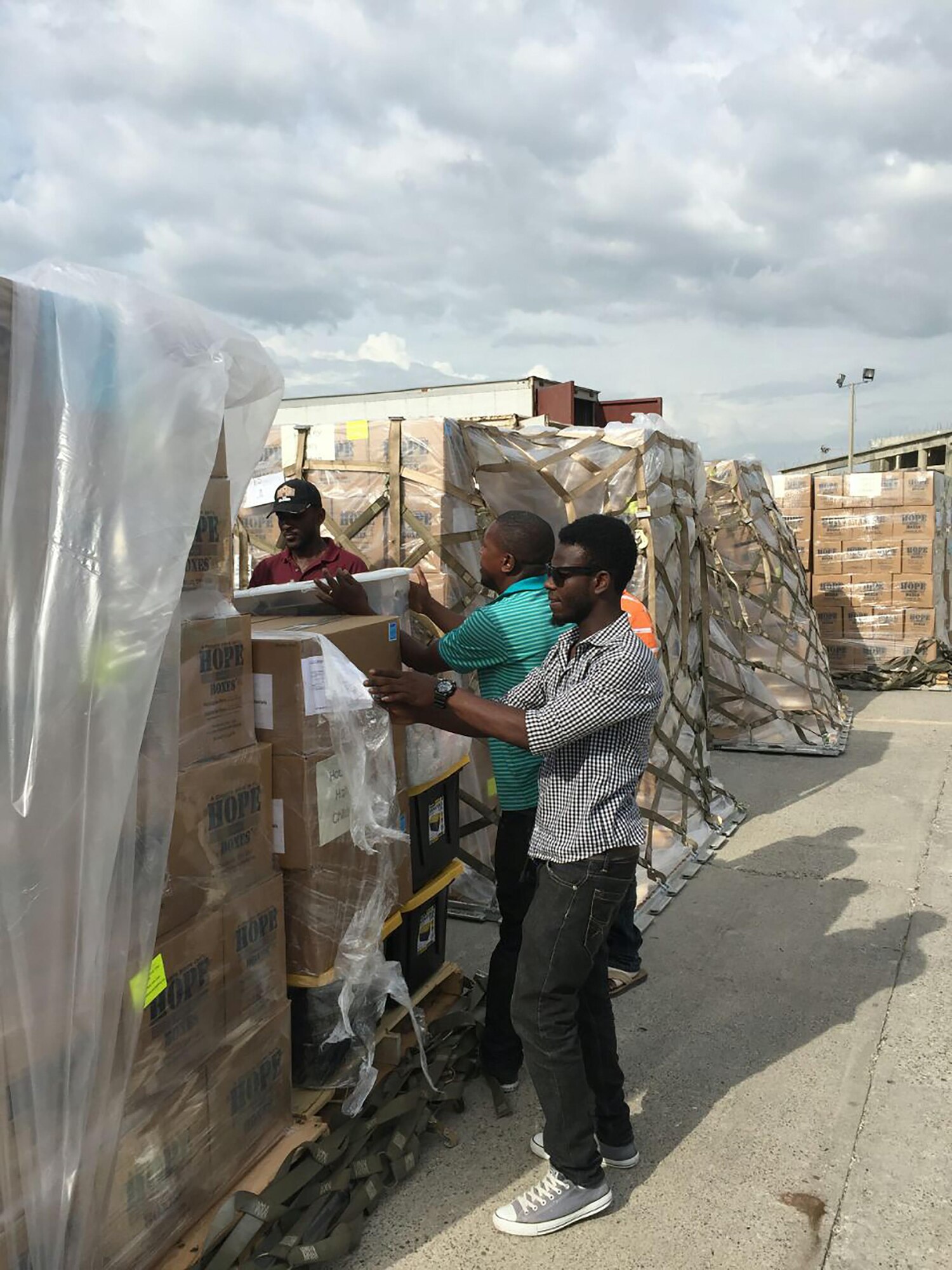 Pallets consisting of more than 100,000 pounds worth of rice and beans are unwrapped and being prepared to load onto trucks to be delivered to those in need in Haiti.