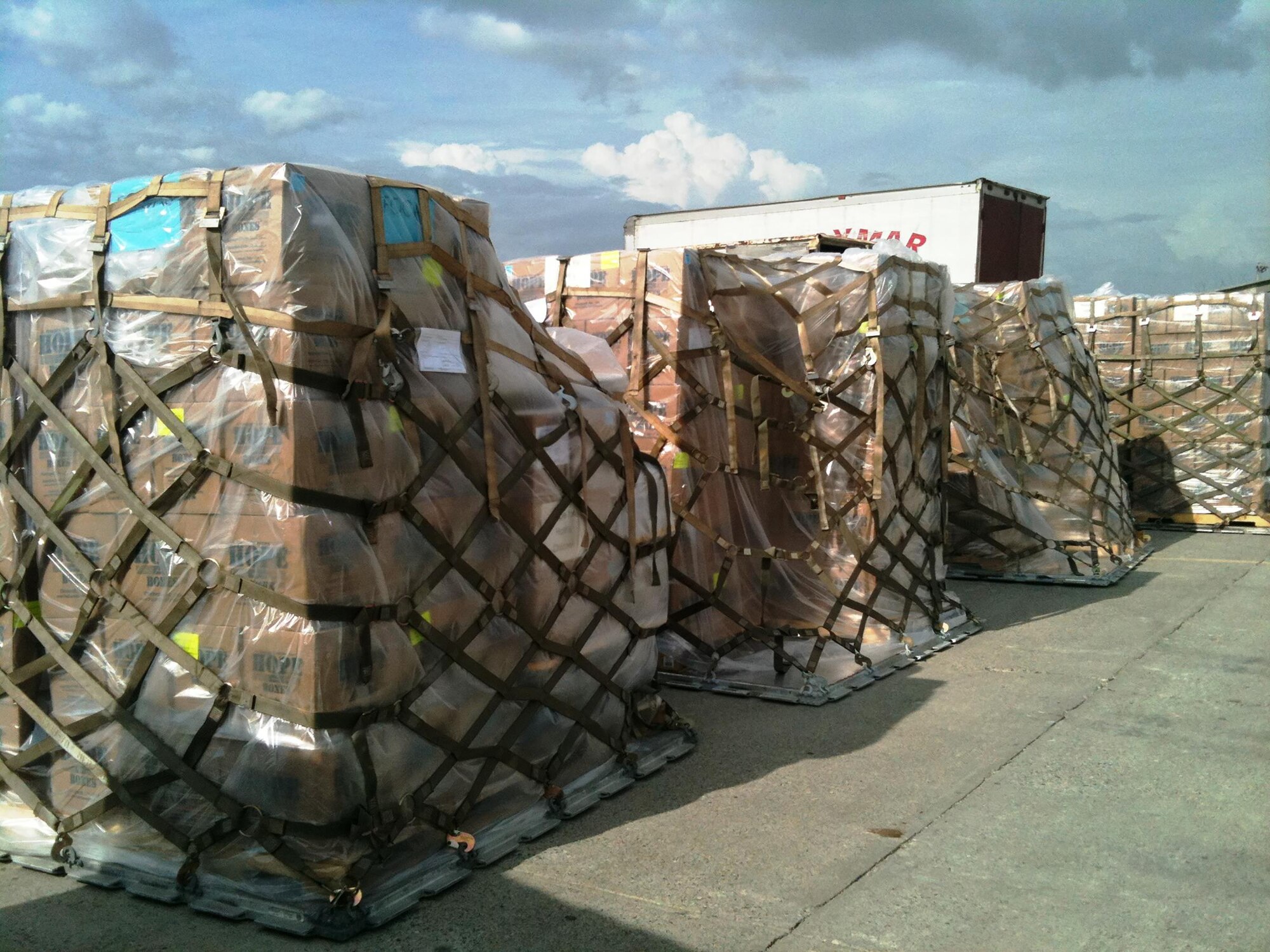 Fifteen pallets of rice and beans, equating to 615,000 meals, sit on the tarmac in Port-Au-Prince after being unloaded from a 445th Airlift Wing C-17 Globemaster III May 26, 2016. The food items, provided by Kids Against Hunger, a ministry of A Child's Hope International from Cincinnati, Ohio, were delivered to the impoverished country through the Denton Program.