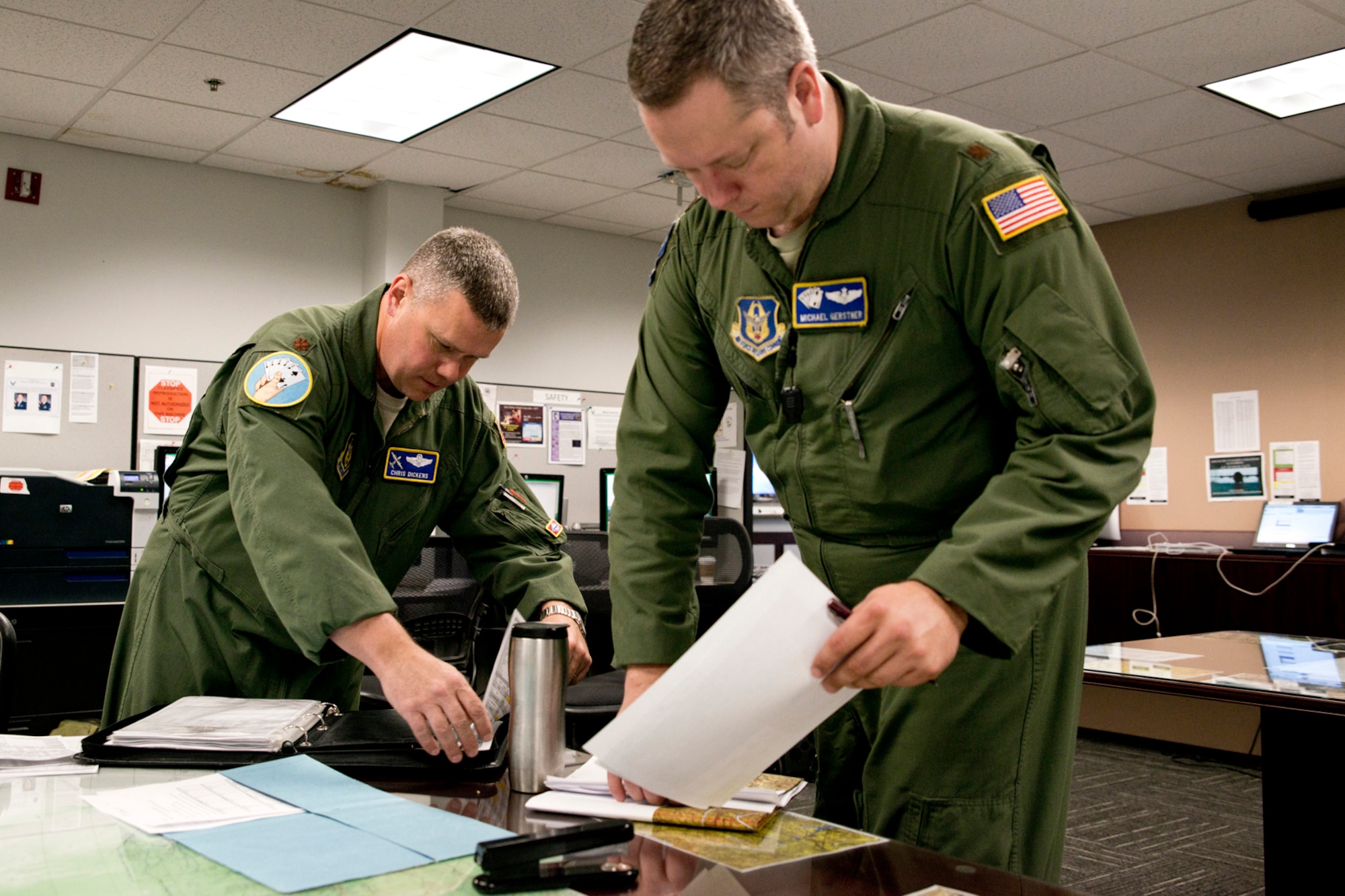 U.S. Air Force Reserve Majs. Chris Dickens and Mike Gerstner, get their paperwork together before a pre-fight briefing at Little Rock Air Force Base, Ark., May 13, 2016. Both Airmen are pilots assigned to the 327th Airlift Squadron and were part of the first C-130J mission flown by an all Reserve aircrew from the 913th Airlift Group since the group’s transition from the “H” to the “J” model. (U.S. Air Force photo by Master Sgt. Jeff Walston/Released)