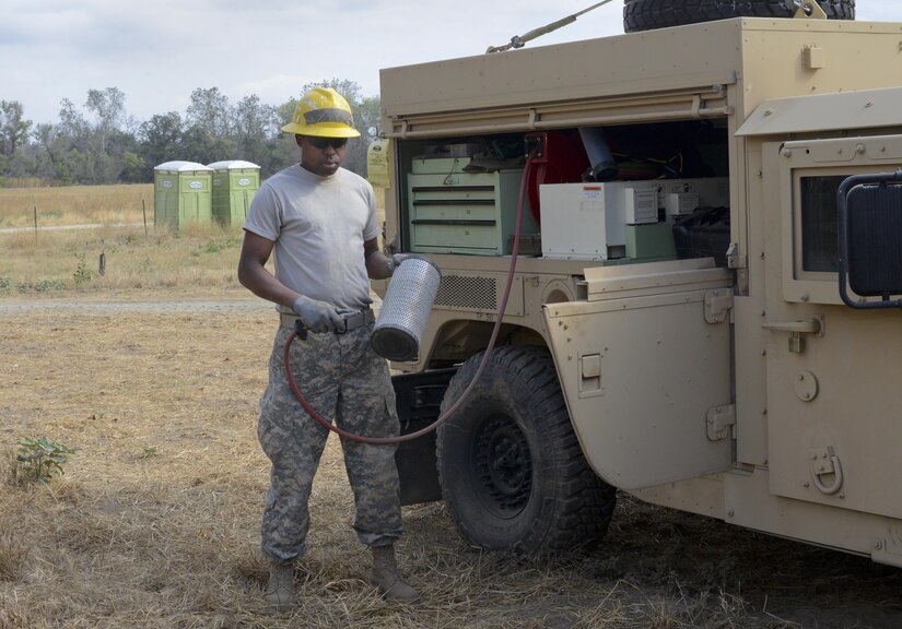 Pvt. Rhoen Barnes works next to his truck in the Kaweah Oaks Preserve at Exeter, California, Monday, May 24, 2016. (U.S. Army Photo by Sgt. Alfonso Corral from the 318th Press Camp Headquarters)