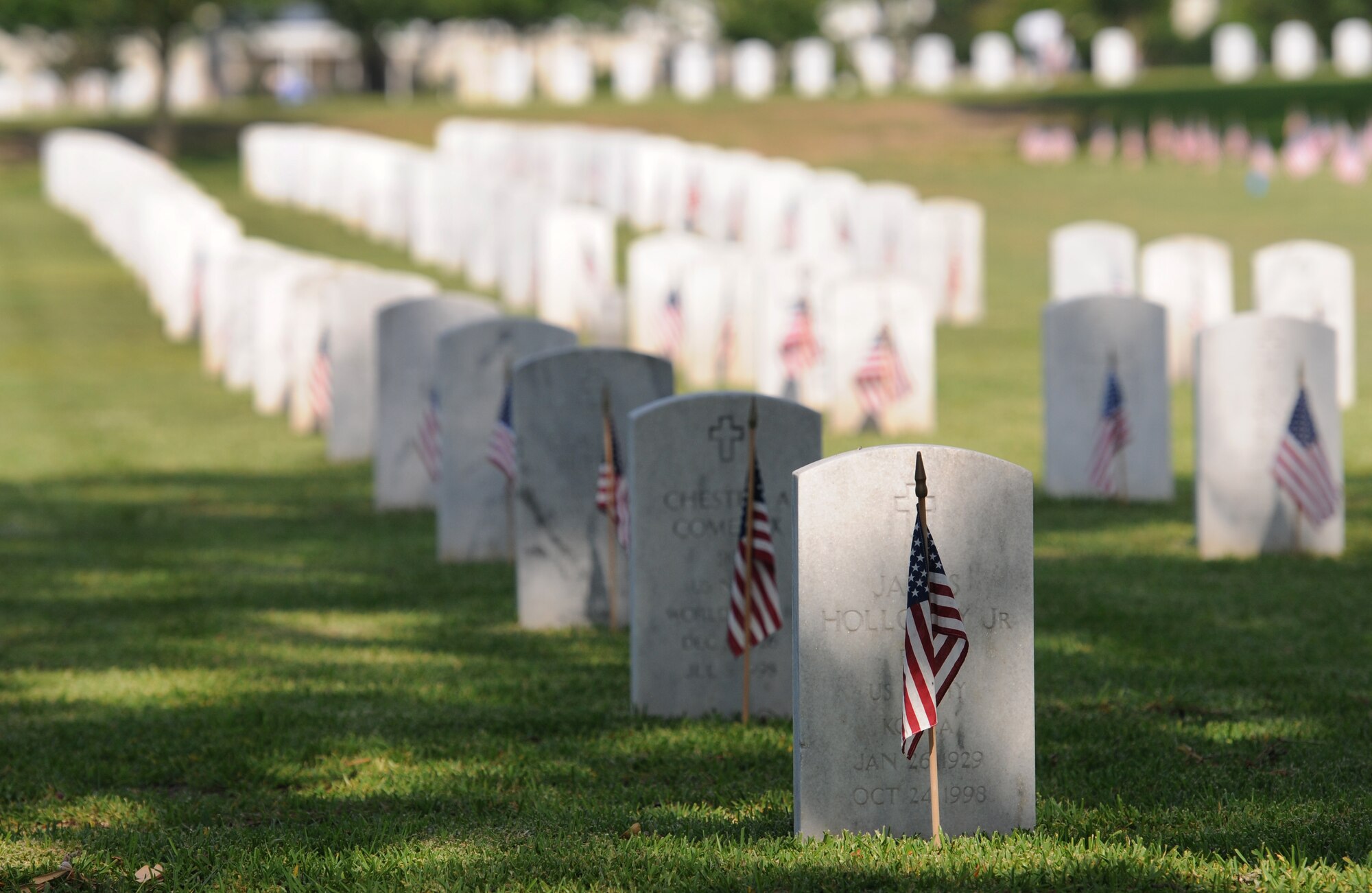 U.S. flags are displayed in front of tombstones during a Memorial Day Ceremony May 30, 2016, Biloxi, Miss. Local veterans, family members and Keesler Air Force Base personnel attended the event at the Biloxi National Cemetery to honor and remember the lives of fallen heroes of the U.S. military. (U.S. Air Force photo by Kemberly Groue)