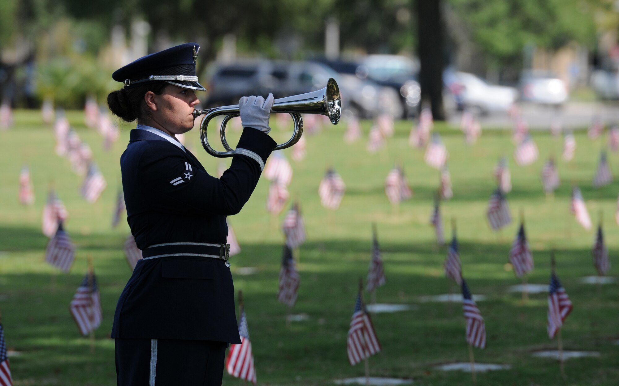Airman 1st Class Brittany Harkins, Keesler Honor Guard member, plays taps during a Memorial Day Ceremony May 30, 2016, Biloxi, Miss. Local veterans, family members and Keesler Air Force Base personnel attended the event at the Biloxi National Cemetery to honor and remember the lives of fallen heroes of the U.S. military. (U.S. Air Force photo by Kemberly Groue)