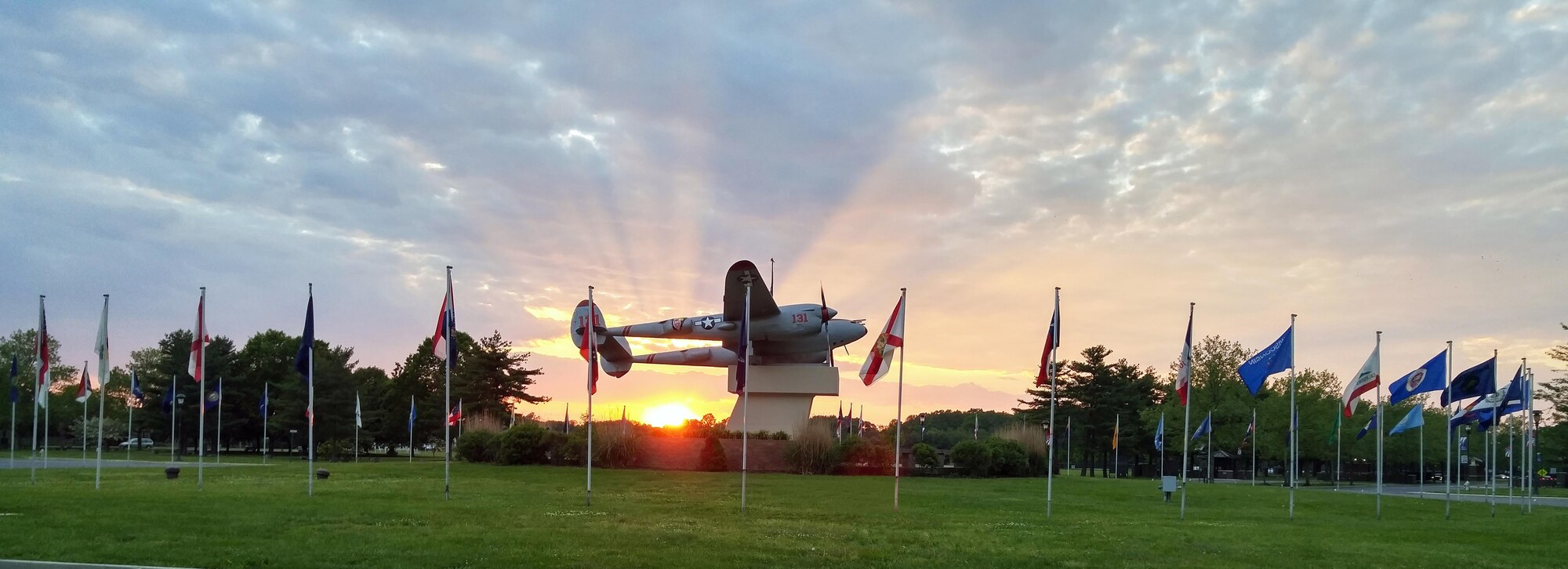 The sun sets behind newly refurbished Pudgy, a P-38  that sits center stage at the main entrance to Joint Base McGuire-Dix-Lakehurst, New Jersey. The  pursuit aircraft was flown by the Joint Base's namesake, Maj. Thomas B. McGuire, a World War II flying ace. (Air Force photo by Master Sgt. Brian Nangle)