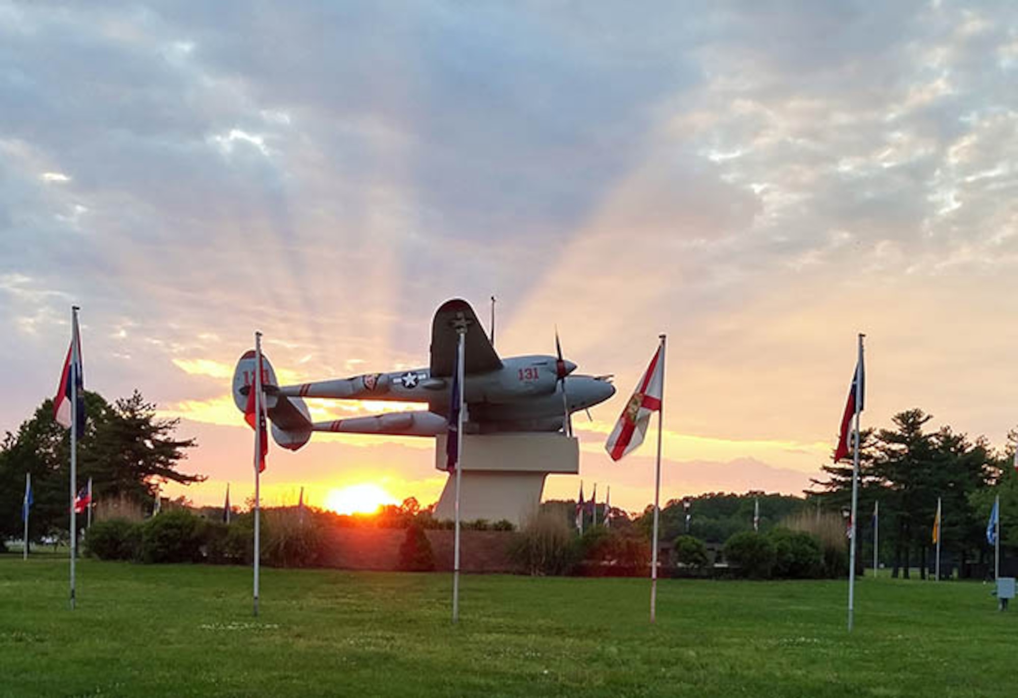 The sun sets behind newly refurbished Pudgy, a P-38 Lightening that sits center stage at the main entrance to Joint Base McGuire-Dix-Lakehurst, New Jersey. The fighter aircraft was flown by the Joint Base's namesake, Maj. Thomas B. McGuire, a World War II flying ace. (Air Force photo by Master Sgt. Brian Nangle)