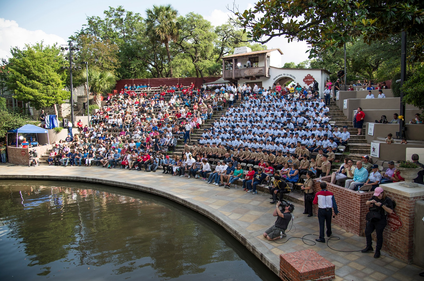 Airmen and Sailors from Joint Base San Antonio and members of San Antonio watch as floats pass by during the Armed Forces River Parade May 21 at the San Antonio Riverwalk. The parade is an annual event held in San Antonio to honor service members past and present.