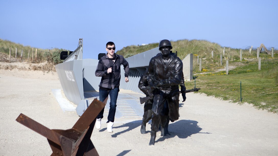 Sgt. James Chambers, correctional specialist, runs down the ramp of a replica American World War Two landing boat at Utah Beach, France, May 25, 2016. More than 70 Marines took part in a five-day, professional military education trip to France to learn about U.S. military history. 