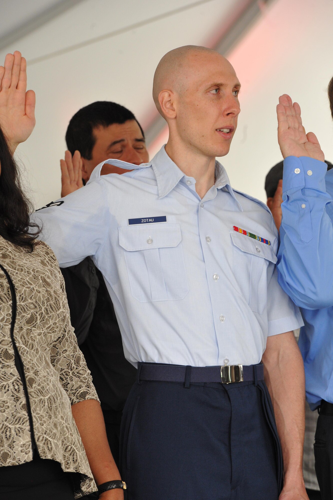 Airman first class Ilya Zotau and 38 other people, hailing from 29 countries, take the Oath of Allegiance to the United States, Monday during a naturalization ceremony held on board the Battleship New Jersey, Camden, N.J. The Air Force reservist is assiged to the 35th Aerial Port Squadron here. . 
